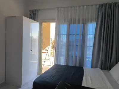 a bedroom with a bed and a sliding glass door at Solo beach front studio or for couple in Hurghada
