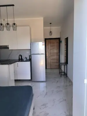 a kitchen with white cabinets and a refrigerator at Solo beach front studio or for couple in Hurghada