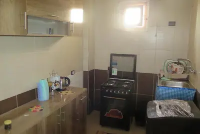 a small kitchen with a stove and a counter at Seashell in Quseir