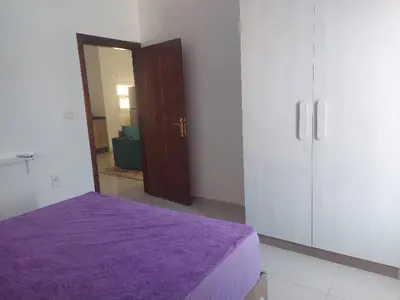 a bedroom with a purple bed and a closet at La BONITA FLAT in Hurghada