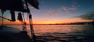 a boat in the water with a sunset in the background at Villa Rebecca Professor's paradise in Luxor
