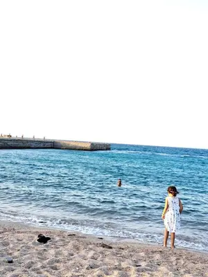 a woman standing on the beach looking at the water at Juliana beach resort in el ahead st in El Gouna
