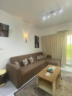 a living room with a brown couch and a coffee table at Fox House Resort Apartment in Hurghada