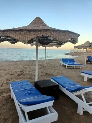 two lounge chairs and an umbrella on the beach at Casablanca star Beach Hurghada كازابلانكا ستار بيتش الغردقة in Hurghada