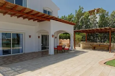 a patio of a house with a table and chairs at White Villa with open lagoon view in Hurghada