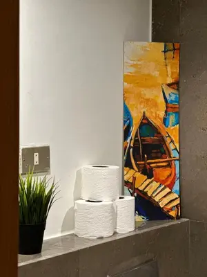 a stack of towels on a shelf in front of a painting at Bright & Lovely 2 Beds Apartment in Scarab Club, El Gouna in Hurghada