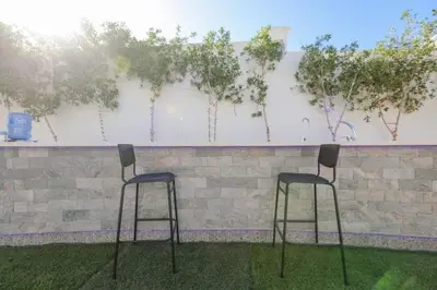 two bar stools in front of a wall with trees at La bonita studio in Hurghada
