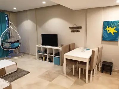 a living room with a table and a tv at Mangroovy- 1BR Sea Breeze Back Sea view in Hurghada
