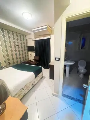 a bedroom with a bed and a bathroom with a sink at فندق جولدن صن العروسه طريق الشيراتون السقالة ميدان محافظة البحر الأحمر 84511 مصر in Hurghada