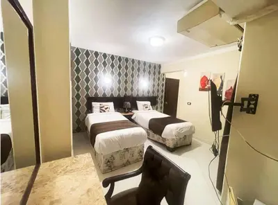 a hotel room with two beds and a mirror at فندق جولدن صن العروسه طريق الشيراتون السقالة ميدان محافظة البحر الأحمر 84511 مصر in Hurghada