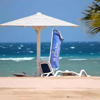 a chair and an umbrella on the beach at Selena bay Resort with private beach - Voyage de rêve in Hurghada