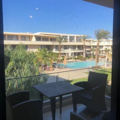 a balcony with a table and chairs and a building at Hotel Apartment in G cribs in Hurghada