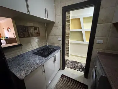 a kitchen with white cabinets and a stove in it at Hurghada Sea View Apartment in Hurghada
