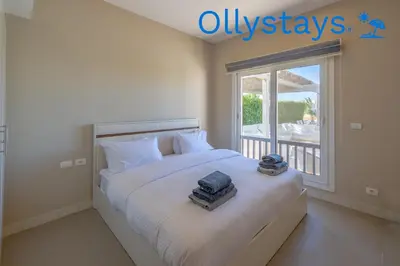 a bedroom with a bed with two towels on it at Ollystays Joubal Lagoon 4 BR Villa Heated Pool in Hurghada