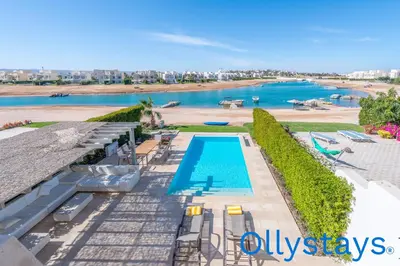 a swimming pool with a view of a beach at Ollystays Joubal Lagoon 4 BR Villa Heated Pool in Hurghada