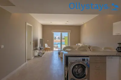 a living room with a washer and dryer at Ollystays Joubal Lagoon 4 BR Villa Heated Pool in Hurghada