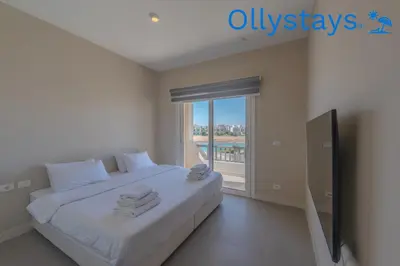 a bedroom with a bed and a large window at Ollystays Joubal Lagoon 4 BR Villa Heated Pool in Hurghada