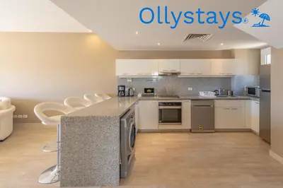 a kitchen with a counter with stools in it at Ollystays Joubal Lagoon 4 BR Villa Heated Pool in Hurghada