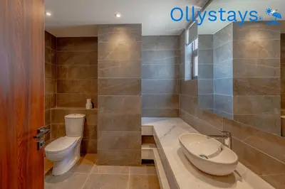 a bathroom with a toilet and a tub and a sink at Ollystays Ancient Sands 4 BR Villa Heated Pool in Hurghada