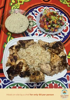 a plate of food with rice and a salad on a table at Gîte Hôtel Ramla Louxor 2 in Luxor