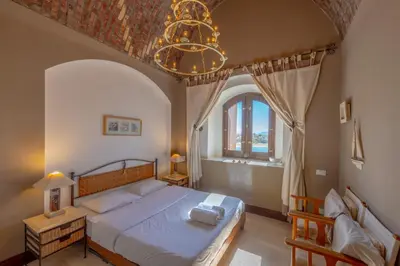 a bedroom with a large bed and a chandelier at Soulful 1BR in Italian Compound / Nubia, El Gouna in Hurghada