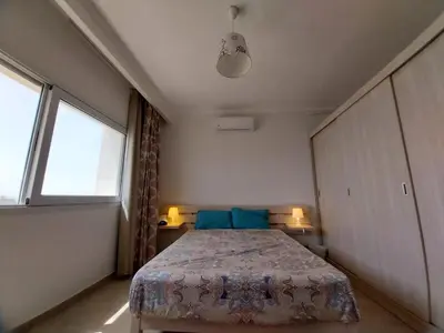 a bedroom with a bed and two windows at Relaxing open Seaview Apartment in Hurghada