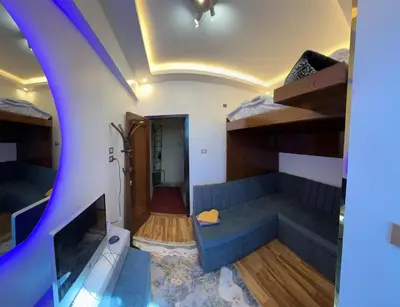 a living room with a blue couch and bunk beds at Unique studio in Aswan