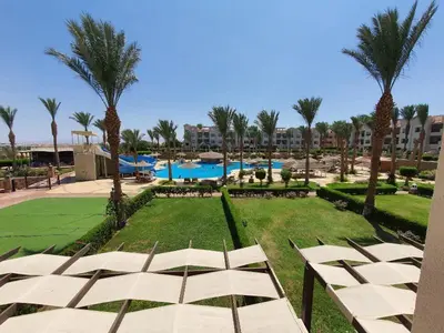 a view of a resort with a pool and palm trees at Sunset pearl, Sahl Hashish in Hurghada