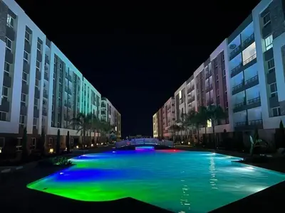 a large swimming pool with green illumination at night at Fanadir Bay Resort in Hurghada