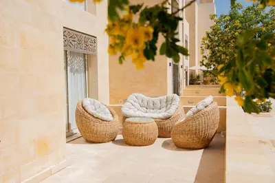a group of wicker chairs and ottoman sitting on a patio at Apartment with large terrace & nice pool area in Hurghada