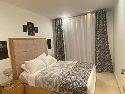 a bedroom with a bed and a window with curtains at one bedroom scarab club el gouna in Hurghada