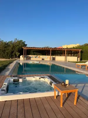 a swimming pool with a table on a wooden deck at 4BR Villa with Private Pool in Gouna in Hurghada