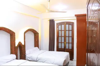a bedroom with two beds and a ceiling fan at Shahd House in Luxor