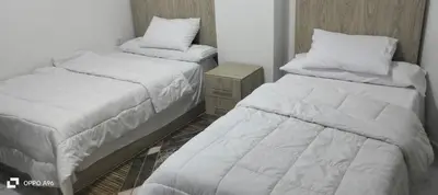 a bedroom with two beds and a nightstand and sidx sidx sidx sidx at جوليانا بيتش ريزورت in Hurghada