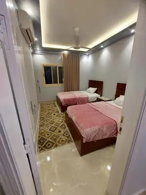 a hotel room with two beds and a doorway at Luxor apartment in Luxor