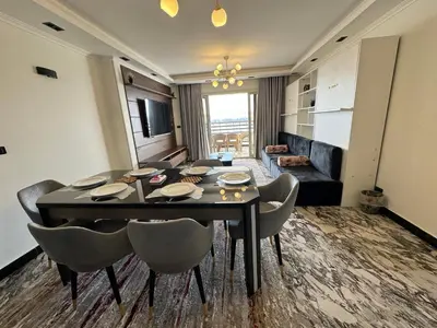 a living room with a dining room table and chairs at Relaxation, fresh air, and a direct view of the Nile in Naj‘ al ‘Amrāb
