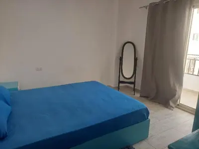 a bedroom with a blue bed and a mirror at Makramia Compound in Hurghada