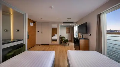 a hotel room with two beds and a window at TIA Boutique Nile Cruise - Accommodation Only - Every Monday from Luxor for 04 & 07 Nights - Every Friday From Aswan for 03 & 07 Nights in Luxor