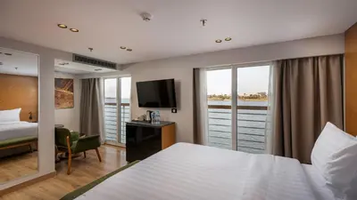 a hotel room with a bed and a view of the water at TIA Boutique Nile Cruise - Accommodation Only - Every Monday from Luxor for 04 & 07 Nights - Every Friday From Aswan for 03 & 07 Nights in Luxor