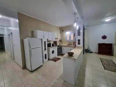 a large kitchen with white appliances in a room at Abo Hisham Nile Flat in Luxor