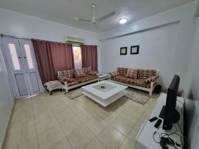 a living room with two couches and a tv at Abo Hisham Nile Flat in Luxor