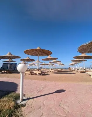 a group of umbrellas on a beach with tables and chairs at Fox Hotel El Ahyaa in Hurghada