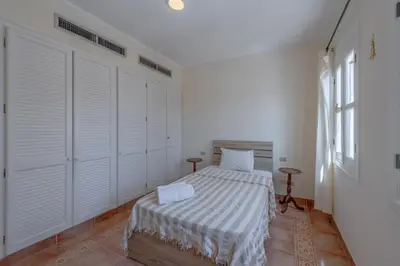 a white bedroom with a bed and a window at SeaView Penthouse with Roof in Marina El Gouna Egypt (Center) in Hurghada
