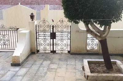 a gate with a tree in front of a building at Villa 2 apartment 4 village veiw infront of Palma de Meritee in Hurghada