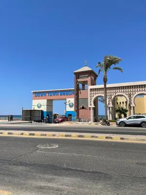 a city street with a building with a palm tree at Villa 2 apartment 4 village veiw infront of Palma de Meritee in Hurghada