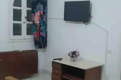 a room with a tv on the wall and a desk at Villa 2 apartment 2 village veiw infront of Palma de Meritee in Hurghada