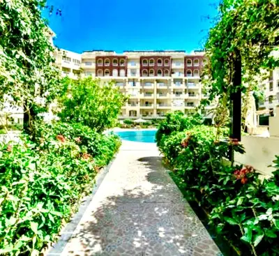 a pathway in front of a building with a swimming pool at Studio Pool view with balcony Florenza Hurghada in Hurghada