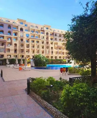 a large apartment building with a pool in front of it at Studio Pool view with balcony Florenza Hurghada in Hurghada