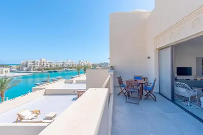 a balcony with a table and chairs and a view of the water at Boutique 2BR in Fanadir Marina - El Gouna. Lagoons & Red Sea in Hurghada