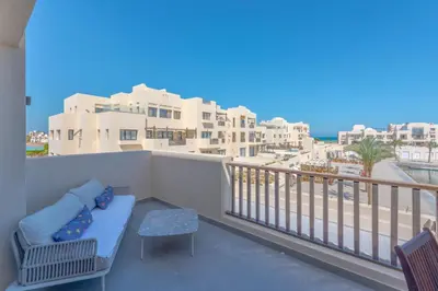a balcony with a couch and a view of the ocean at Boutique 2BR in Fanadir Marina - El Gouna. Lagoons & Red Sea in Hurghada